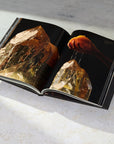 View of interior spread from the book ARQUIVISTAS by the Dorow Collection. Macro view of giant quartz and wider image of a hand holding a honey comb dripping honey on the top of the citrine quartz.
