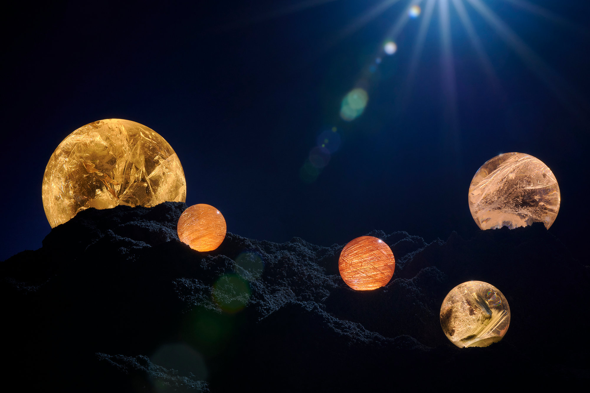 Quartz Spheres glowing against a dark background and placed on black sand. View of interior spread from ARQUIVISTAS, a book by the Dorow Collection. 