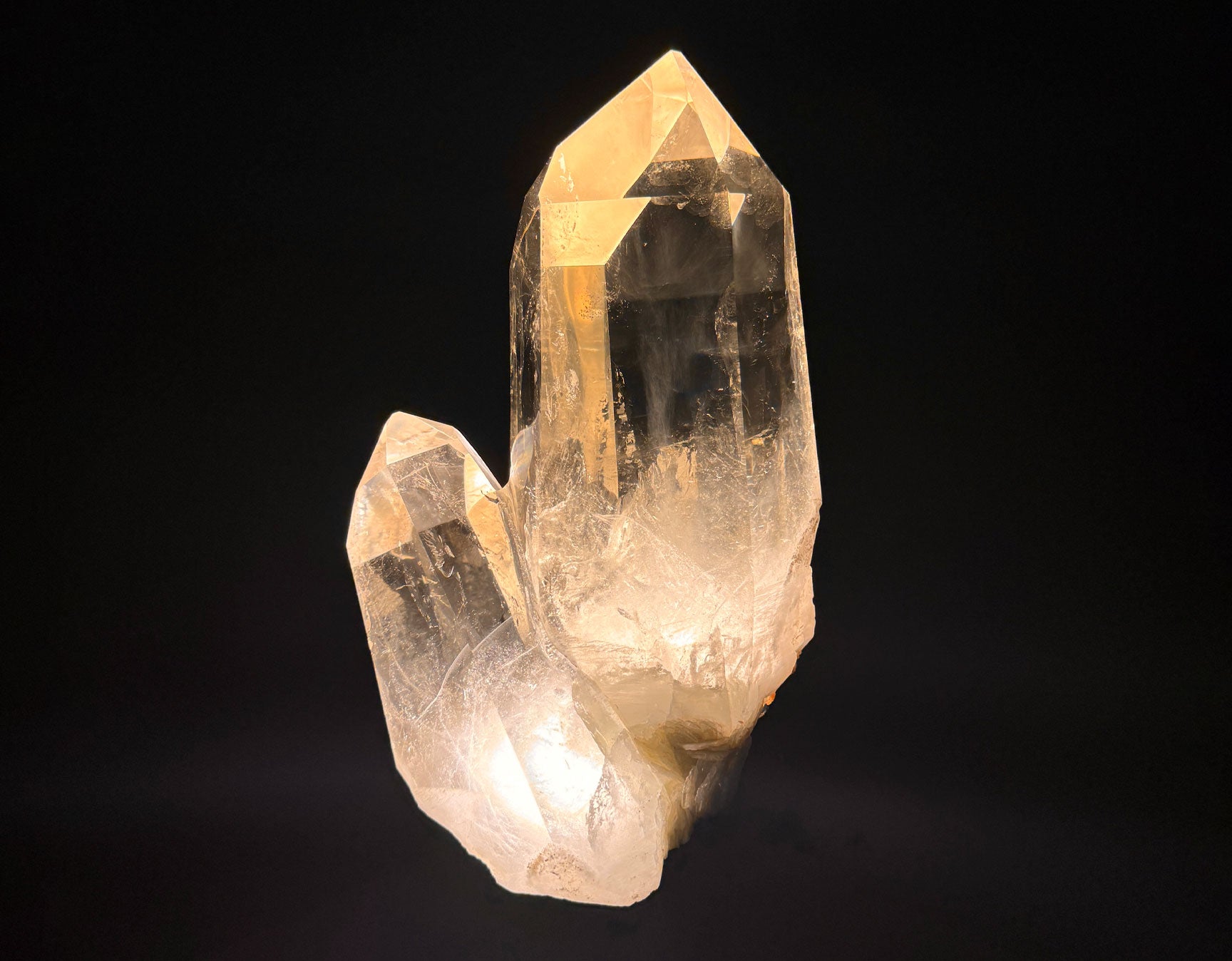 Photograph of an illuminated quartz crystal from the Dorow Collection against a black background. 